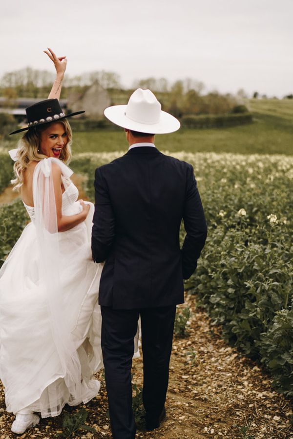 Country theme Stone Barn wedding with bride and groom wearing cowboy hats