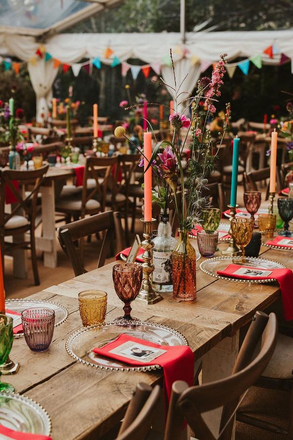 Clear marquee wedding reception in a back garden with colourful flower and table decor 