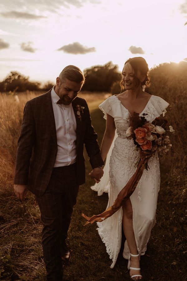 Bride in a bespoke Emma Beaumont Atelier wedding dresss with the groom in a grey suit.