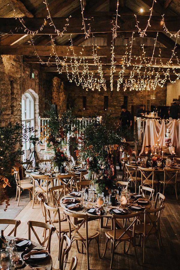 Autumn theme wedding at Askham Hall in cumbria with fairy lights and tree centrepieces 