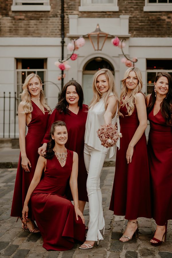 Bride with bridesmaids in dark red bridesmaid dresses for townhouse wedding.
