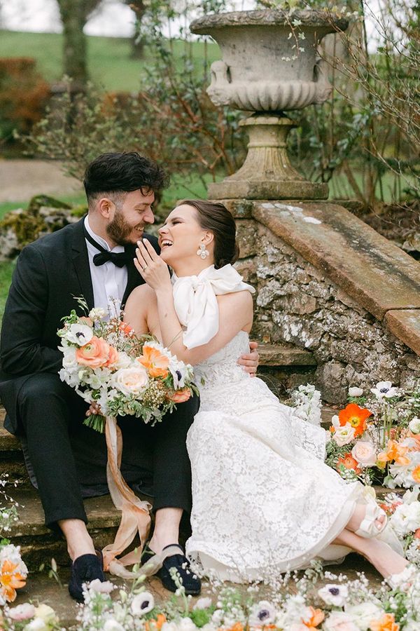 Romantic Holesfoot wedding inspiration with orange and white flowers, lace and beaded wedding dresses and an iced wedding cake