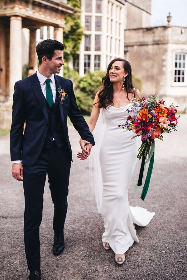 Kyha wedding dress worn by bride walking with groom at Elmore Court.