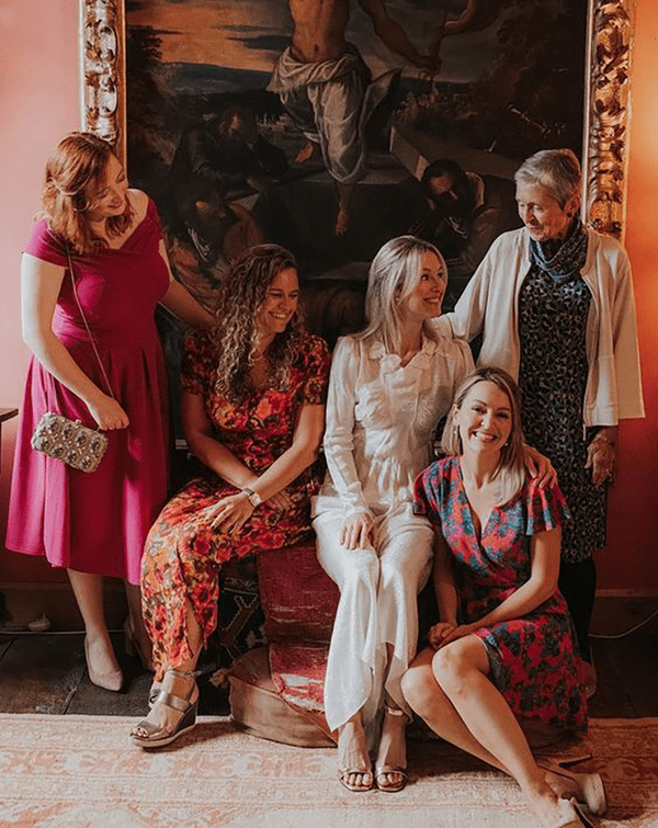 Guests wearing casual wedding attire, including pink midi dresses and floral jumpsuits