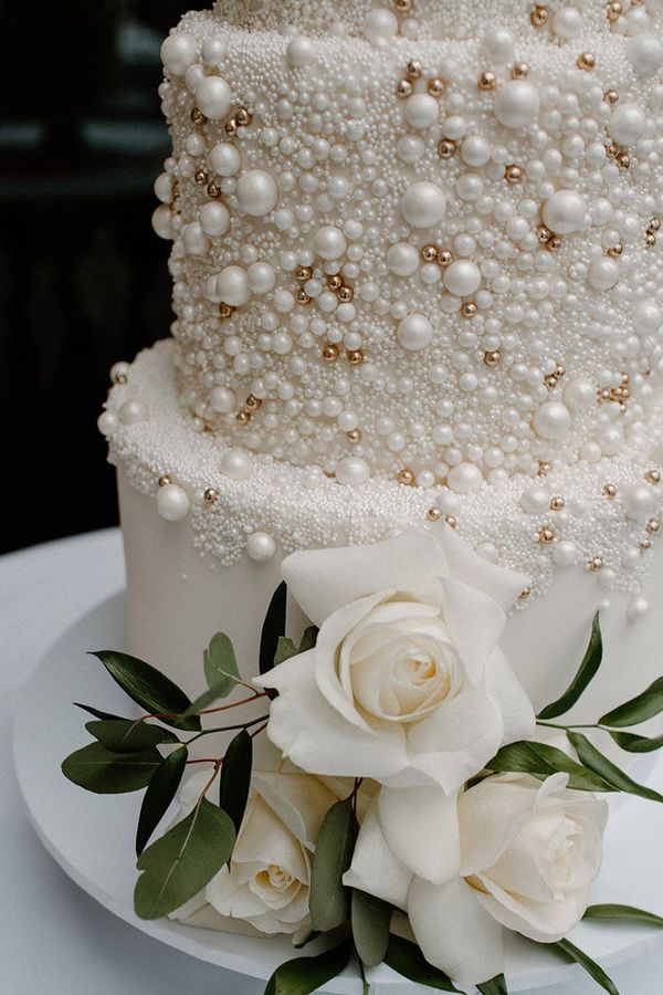 White iced four tier wedding cake with pearl design