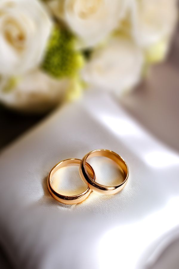 Close up of two wedding rings, placed on a cushion, highlighting marriage