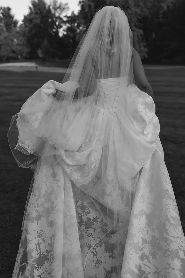 Bride wearing floral corset wedding dress with long train