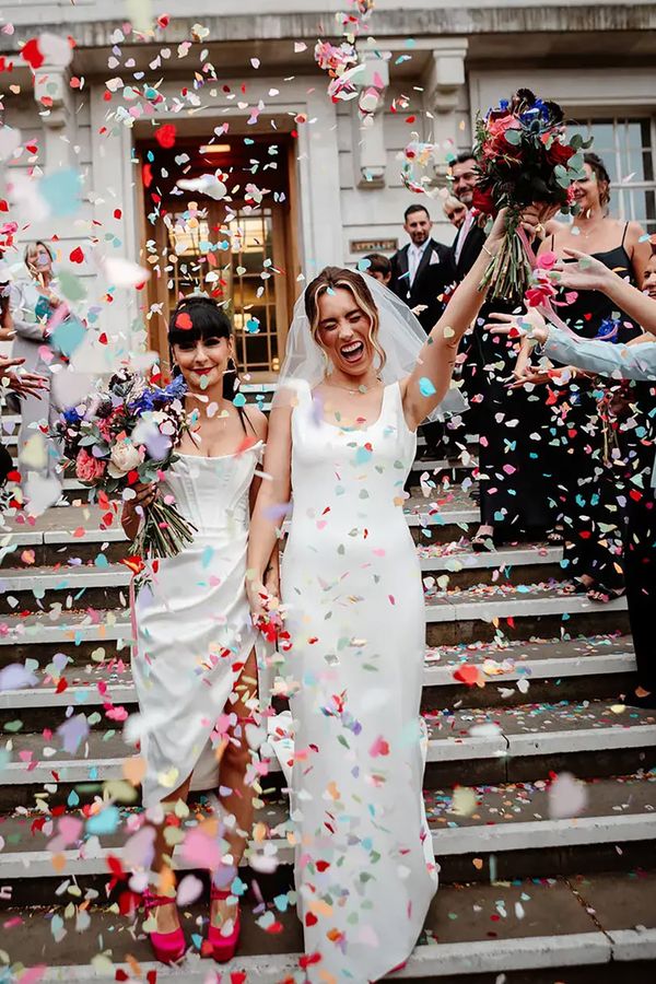 Colourful confetti exit on steps at town hall wedding