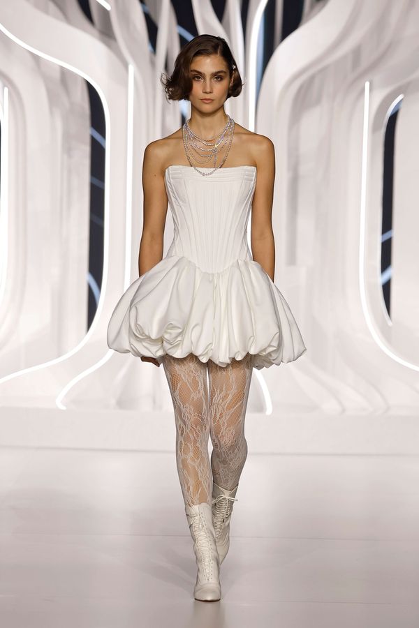 Modern short wedding dress with corset bodice, bubble skirt and lace stockings at Barcelona Bridal Fashion Week 2026