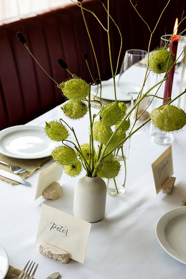 White bud vases with green florals and blooms with place names