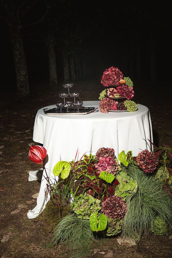 Burgundy and green colour trend wedding flowers on oval table