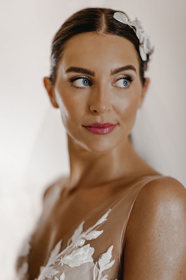 Bride with a pink lip and glittery eyeshadow smiling for wedding