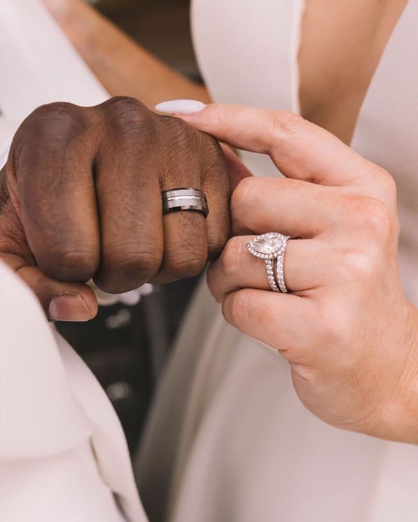 Bride and groom showing off new wedding bands with lab grown diamond engagement ring for bride