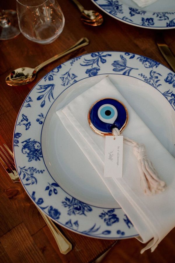 White and blue china plates with evil eye decorative charm on napkin