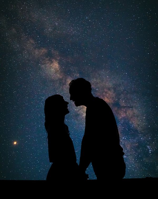 silhouette of couple with galaxy night sky astrotourism honeymoon trend
