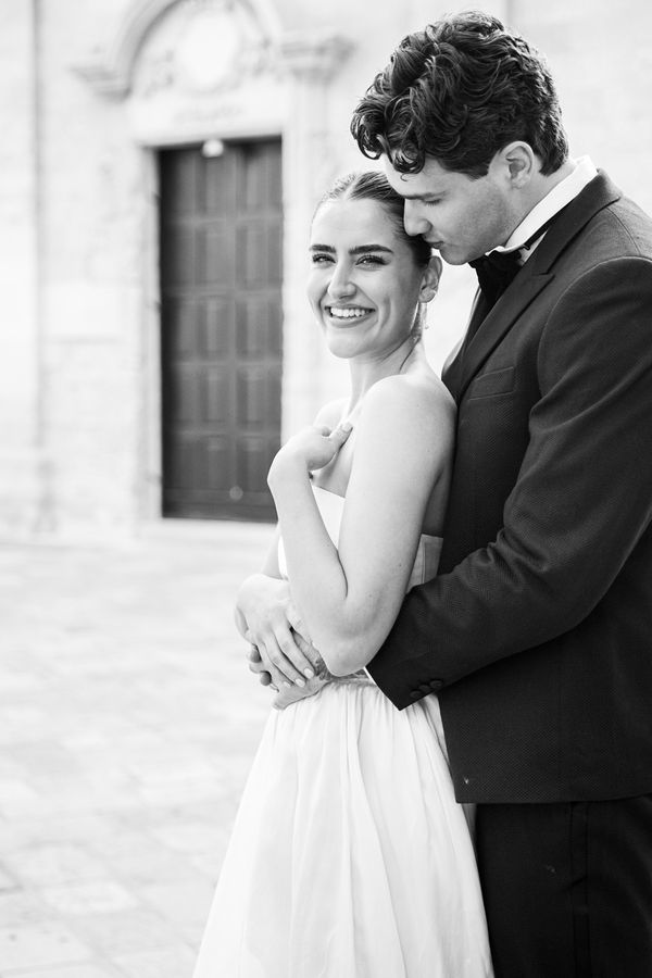 Black and white image of a bride and groom cuddling at a wedding in Puglia