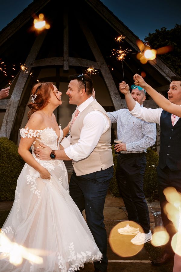 Bride and Groom enjoying their wedding day celebrating with their loved ones with sparklers. Photo by Vicky Lewis Photography