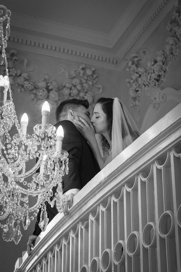 Couple kissing on balcony. Rachel Hannah Weddings