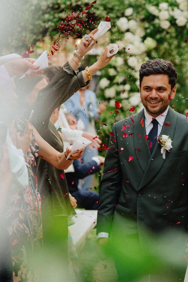 Bride and groom walk through thrown confetti
