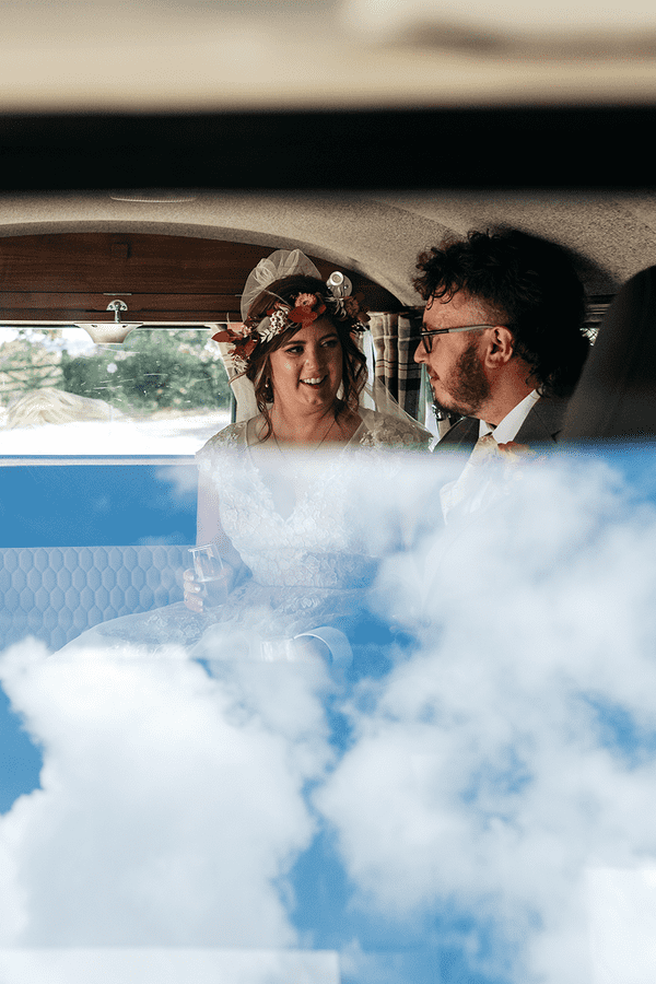 Bride and groom in their Volkswagen campervan after getting married on a sunny day