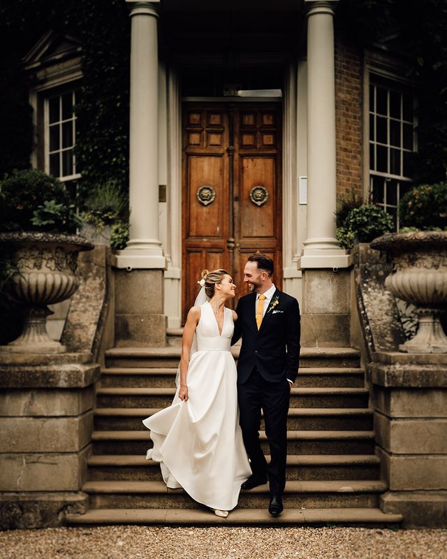 Hampton Court House wedding in Surrey with bride and groom posing together.
