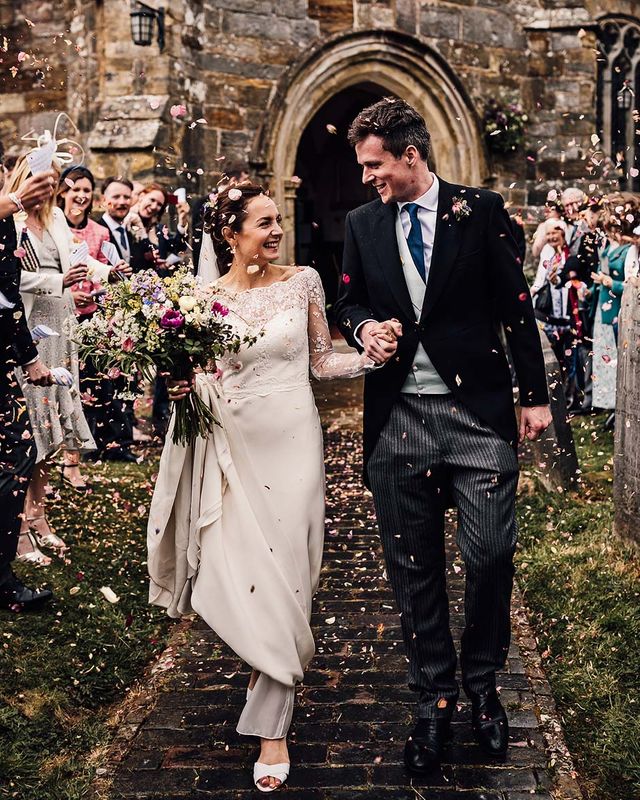 Bride and groom have colourful confetti exit from their church wedding ceremony before going to Wadhurst Castle for their reception.