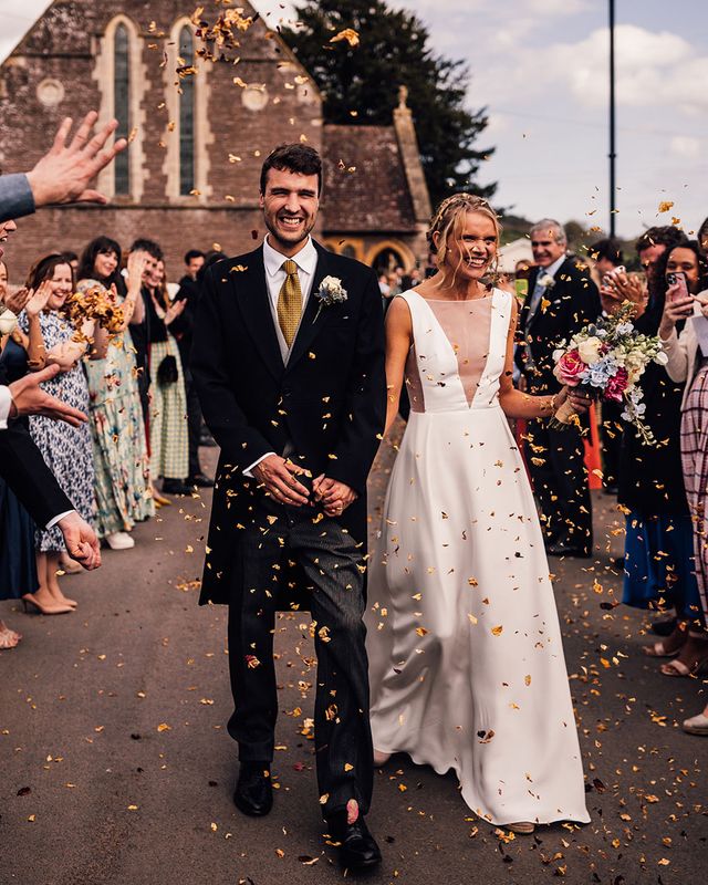 Bride walking with the groom out to confetti in a Andrea Hawkes wedding dress.