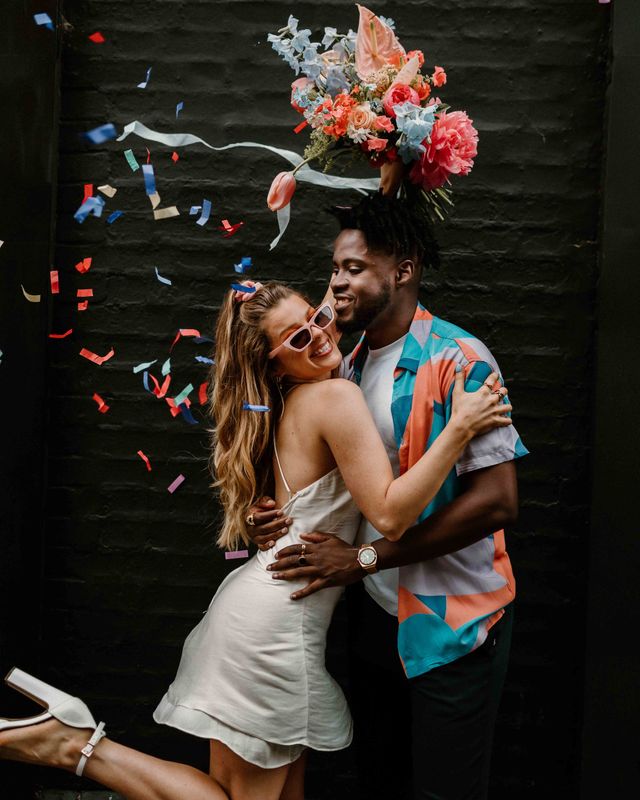 Fun East London elopement with fabric wedding banner, short wedding dress and colourful flowers
