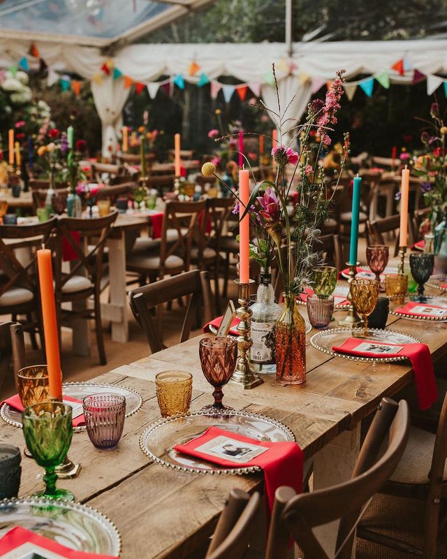 Clear marquee wedding reception in a back garden with colourful flower and table decor 
