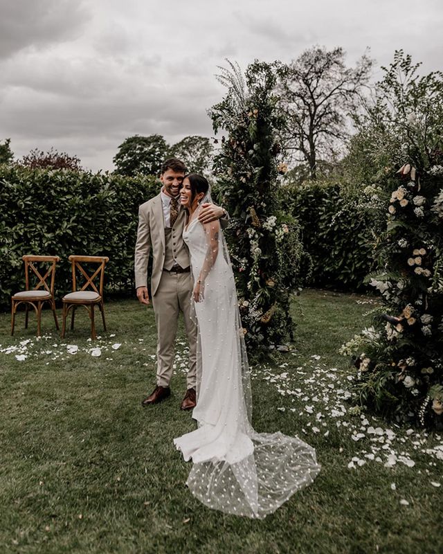 Indian and English multicultural garden wedding with a clear marquee and a bride in a slip wedding dress and pearl veil by Epic Love Story