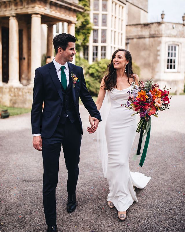 Kyha wedding dress worn by bride walking with groom at Elmore Court.