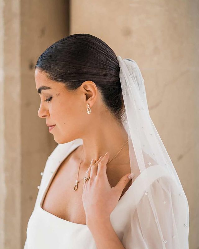 Bride in square neck wedding dress with sheer pearl embellished bridal veil and dainty silver pearl bridal jewellery