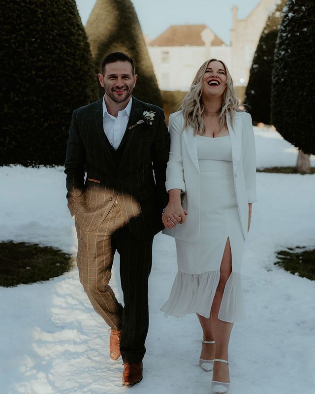 A couple holding hands in the snow for winter wedding
