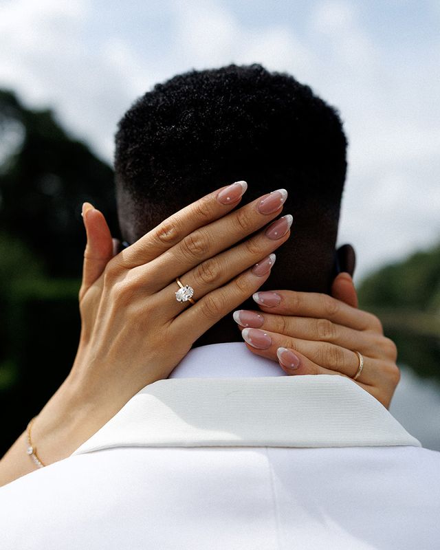 bridal-ring-and-french-manicure-hands-on-grooms-shoulders-enagement-party
