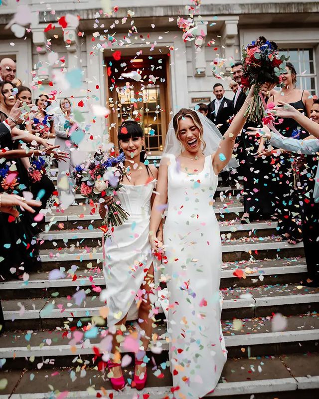 Colourful confetti exit on steps at town hall wedding