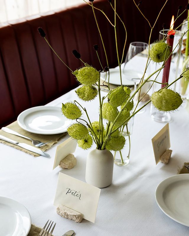 White bud vases with green florals and blooms with place names