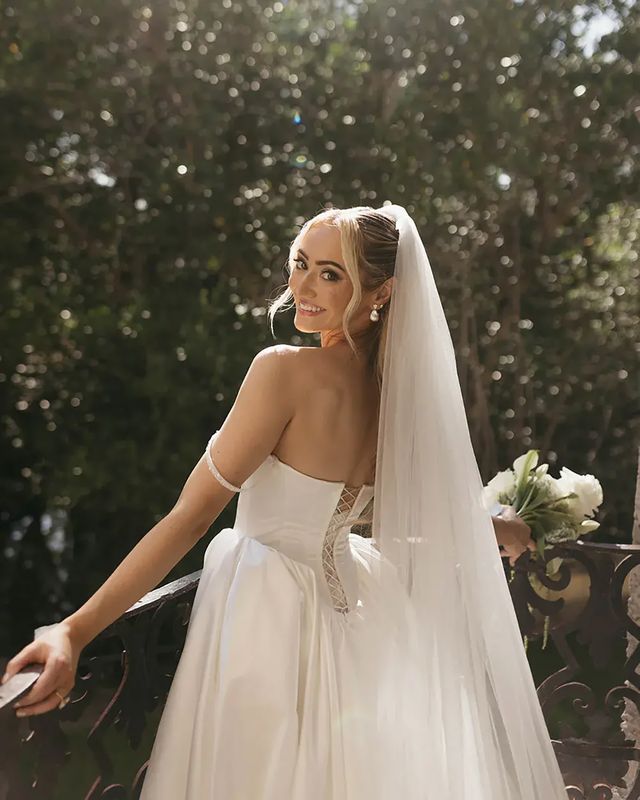 Bride in princess wedding dress with veil and white flower bouquet