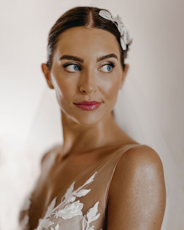 Bride with a pink lip and glittery eyeshadow smiling for wedding