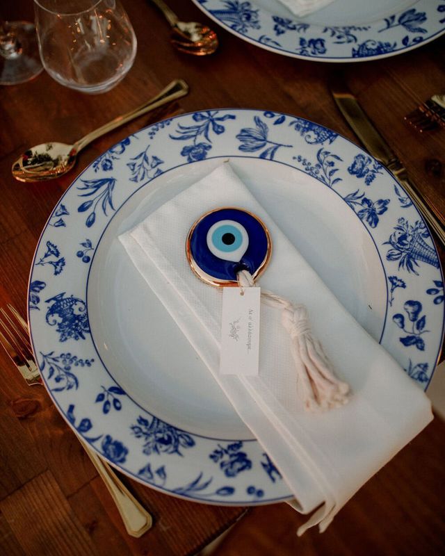 White and blue china plates with evil eye decorative charm on napkin