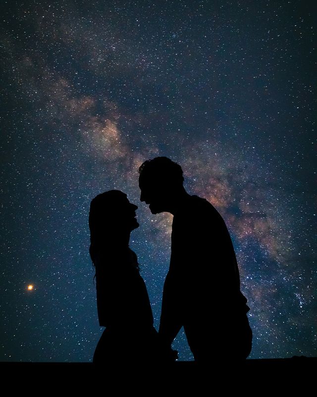 silhouette of couple with galaxy night sky astrotourism honeymoon trend