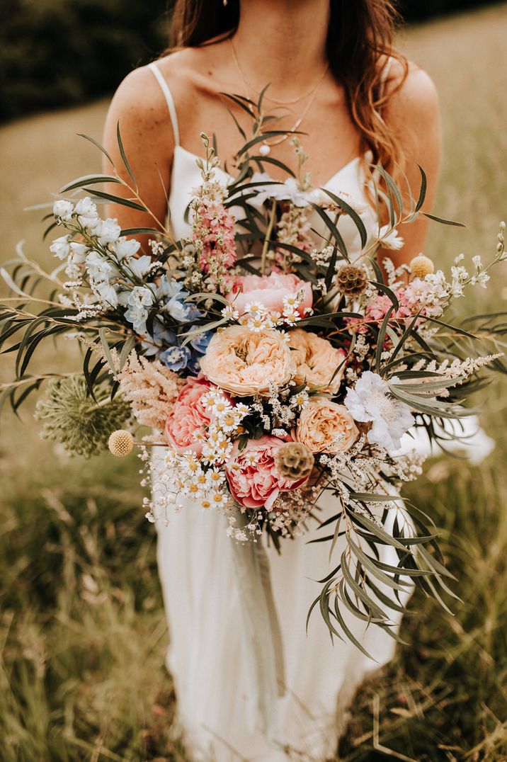 Large pastel wild bouquet held by bride