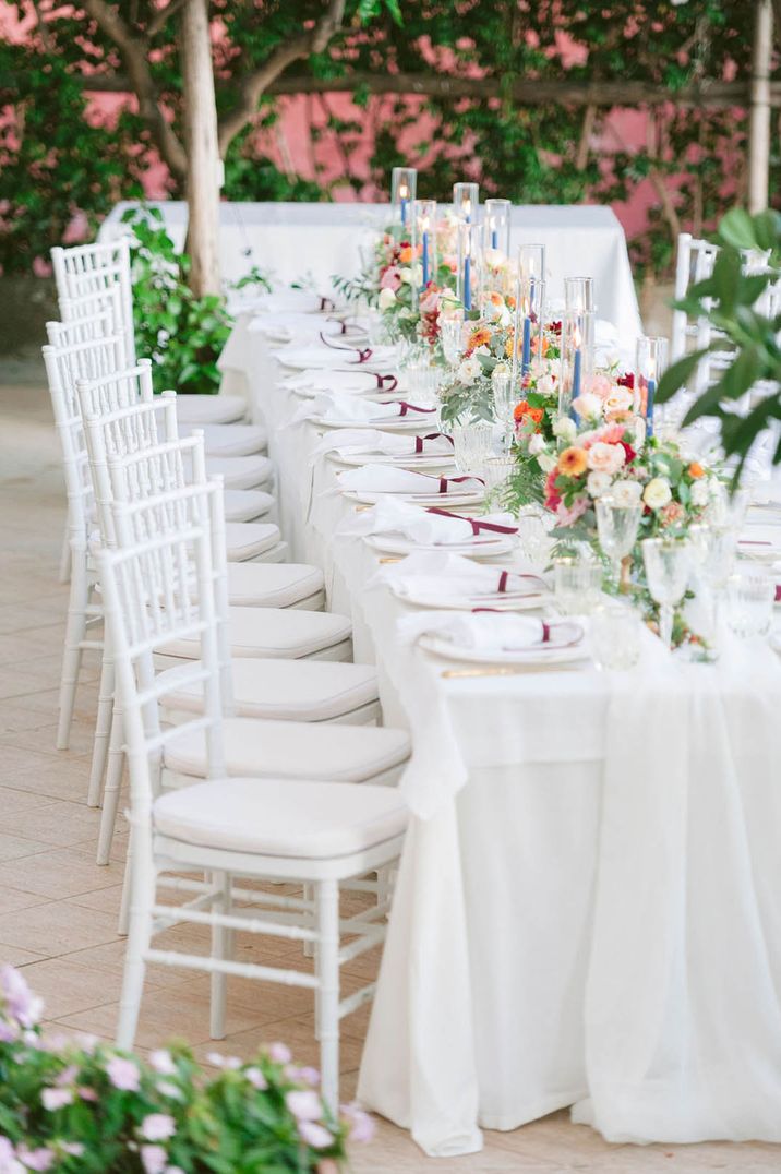 White wedding tablescape for an outdoor Italian LGBTQI+ wedding with tapered candles and floral centrepieces