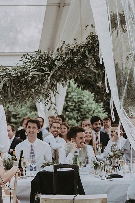 groom speech at an English country garden marquee wedding at the family home with greenery decor 