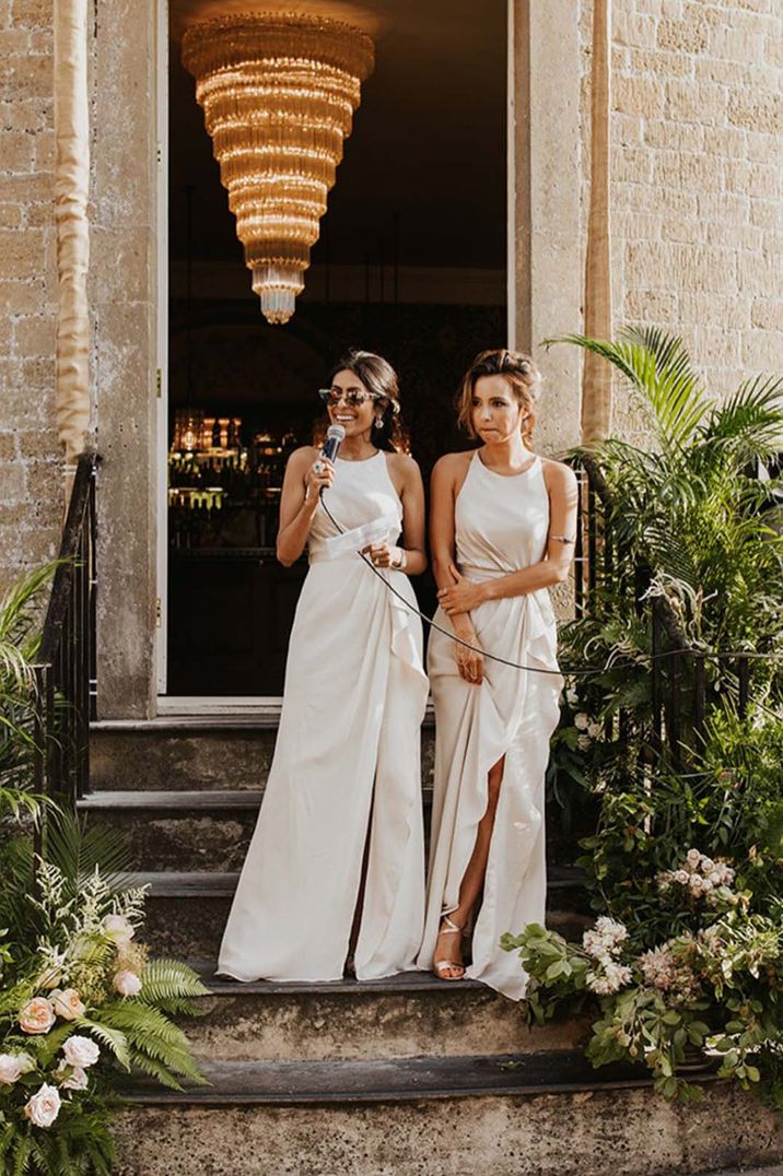 Bridesmaids giving speeches in long satin white bridesmaid dresses and sunglasses