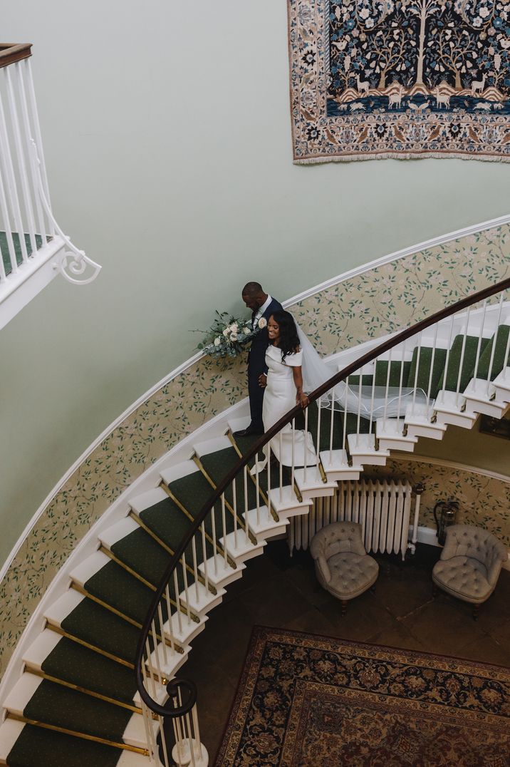 Bride and groom descending the staircase at Sudanese wedding ceremony in Middleton Lodge wedding venue