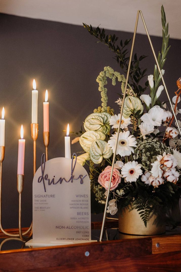 Acrylic drinks wedding sign and neutral coloured candelabra with white, pink and neutral floral bouquet