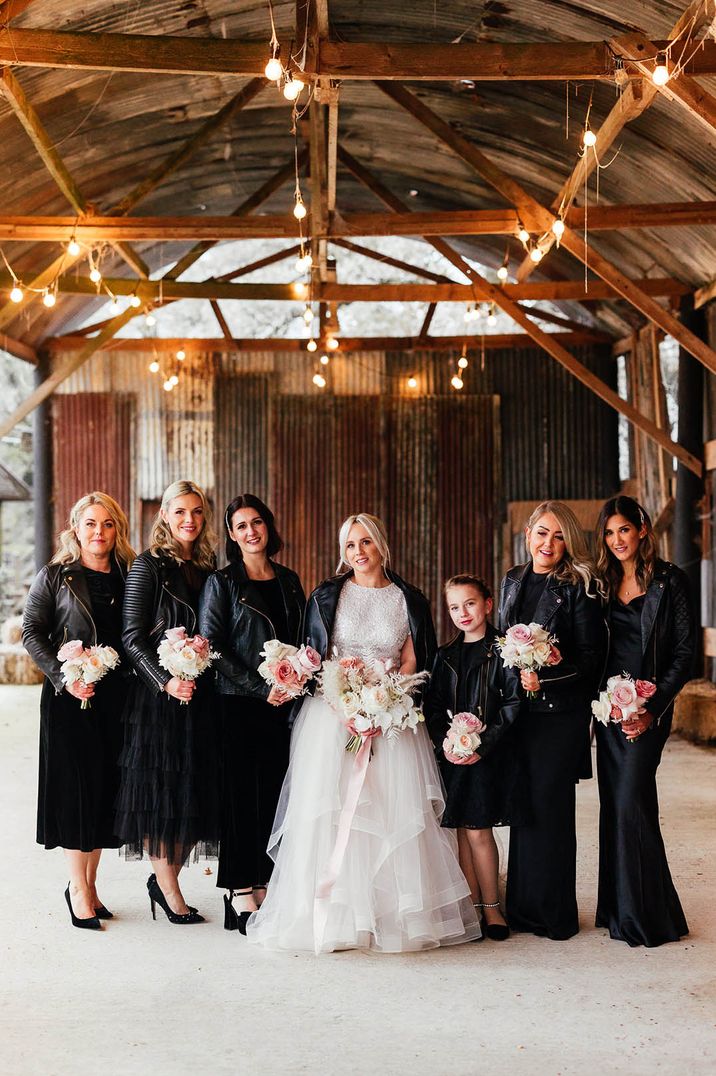 Bridal party in black bridesmaid dresses and leather jackets with the bride in tulle bridal skirt and beaded top separates 