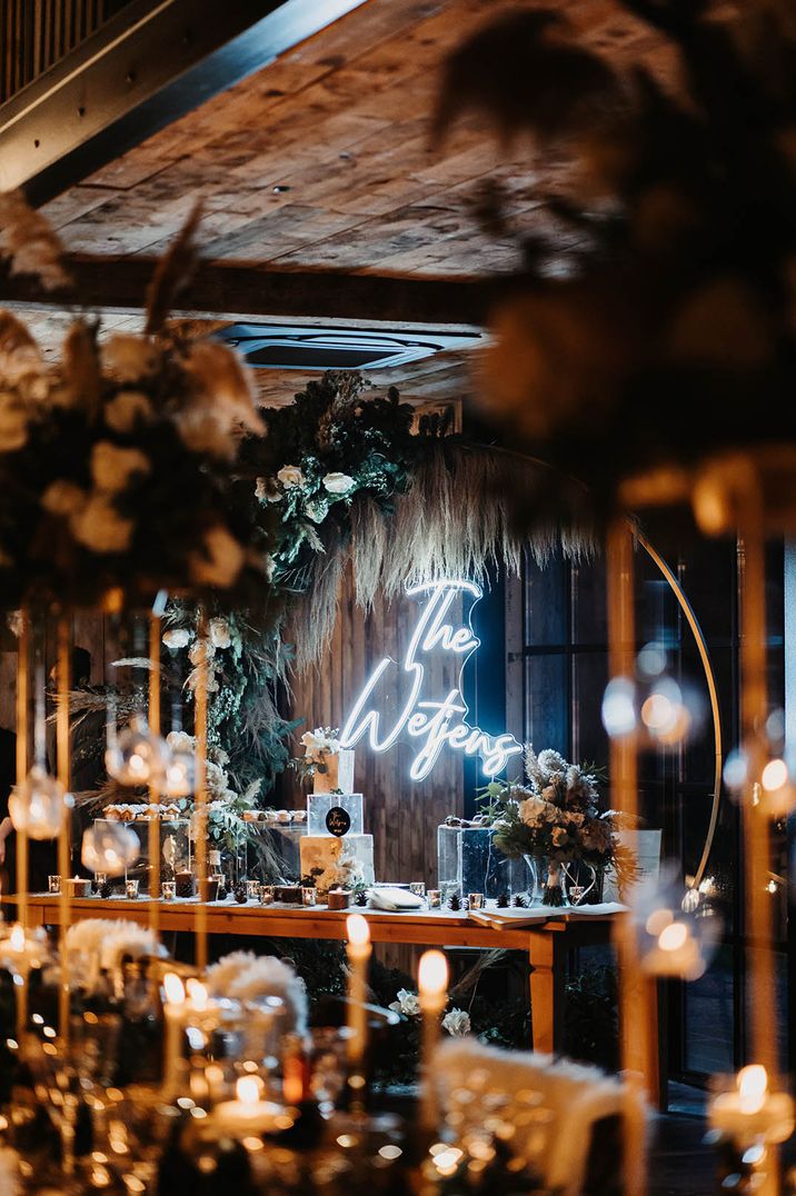 Bright white personalised neon sign and moongate as backdrop to the bride and groom on the top table 