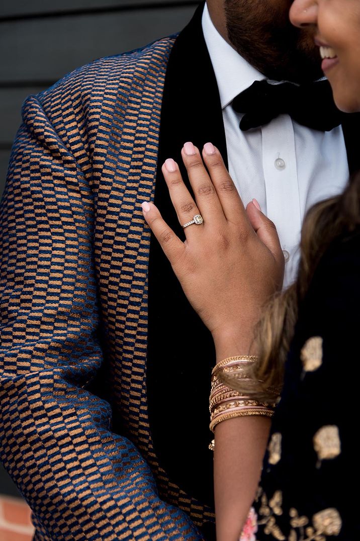 Bride with yellow diamond engagement ring resting her hand on her partner's patterned suit jacket 