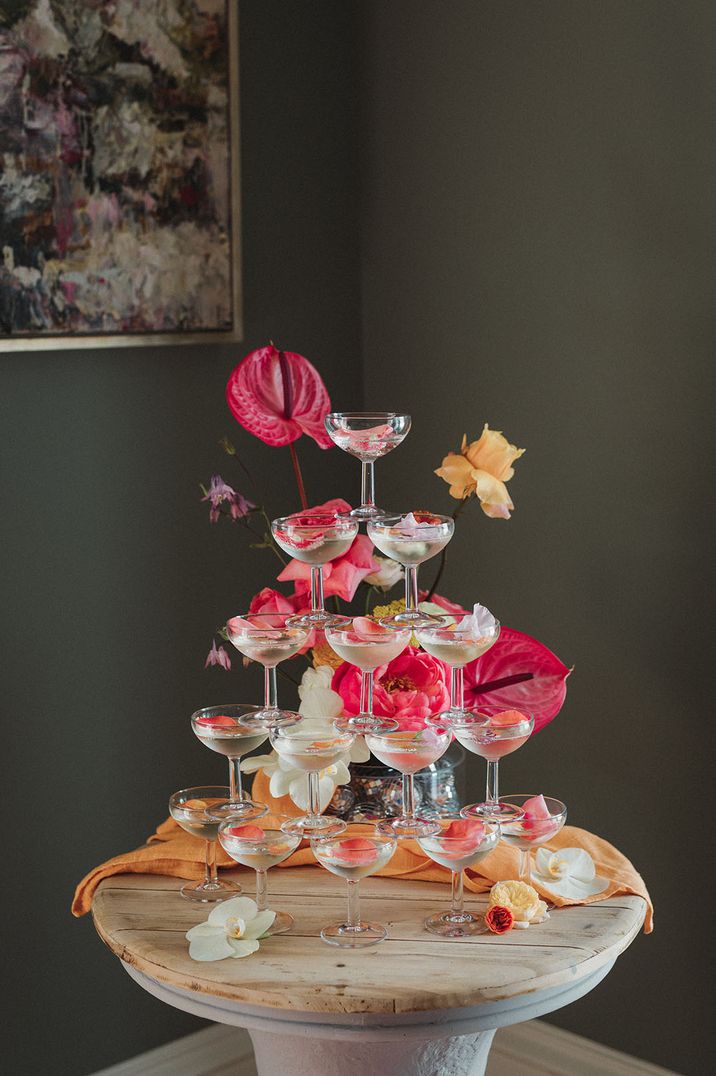 Champagne tower with pink petals and flowers for decoration  